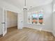 Bright dining room with hardwood floors, modern lighting, and large windows at 13126 Macon Hall Dr, Mint Hill, NC 28227