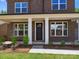 Charming brick home entrance with manicured landscaping and white-trimmed windows at 13126 Macon Hall Dr, Mint Hill, NC 28227