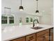 Bright, open kitchen featuring a large island with a quartz countertop and a black faucet at 13126 Macon Hall Dr, Mint Hill, NC 28227