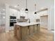 Modern kitchen with white cabinets, stainless steel appliances, and a large island at 13126 Macon Hall Dr, Mint Hill, NC 28227