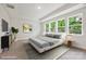 This staged main bedroom features a modern bed and many windows overlooking trees at 13126 Macon Hall Dr, Mint Hill, NC 28227
