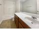 Well-lit bathroom with white countertop, brown cabinets, and shower-tub combo at 13903 Mallard Roost Rd, Charlotte, NC 28262