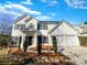 Beautiful two-story home with a two-car garage, black shutters, and professional landscaping at 13903 Mallard Roost Rd, Charlotte, NC 28262