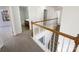 Upstairs hallway featuring wood railing and doors to bedrooms and bathrooms at 13903 Mallard Roost Rd, Charlotte, NC 28262