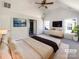 Staged main bedroom featuring carpet flooring, a ceiling fan, and two large windows at 13903 Mallard Roost Rd, Charlotte, NC 28262