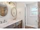 Bathroom features a double sink vanity with marble countertops, oval mirrors, and dark wood cabinets at 14325 Rocky River E Rd, Davidson, NC 28036