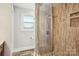 Bathroom features a walk-in shower with glass doors, tiled walls and pebble floor and a toilet at 14325 Rocky River E Rd, Davidson, NC 28036
