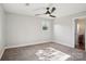 Bedroom featuring neutral colored walls and carpet, a ceiling fan, and a bright window at 14325 Rocky River E Rd, Davidson, NC 28036
