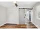 Sunlit bedroom features hardwood floors and a modern sliding door to the next room at 14325 Rocky River E Rd, Davidson, NC 28036