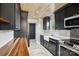 Well-appointed kitchen with stainless steel appliances, marble countertops, wooden accent, and designer finishes at 14325 Rocky River E Rd, Davidson, NC 28036