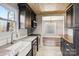 Modern kitchen with stainless steel appliances, marble countertops, and wood ceiling, connecting to dining area at 14325 Rocky River E Rd, Davidson, NC 28036