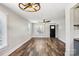 Bright living room featuring hardwood floors, a ceiling fan, and plenty of natural light from large windows at 14325 Rocky River E Rd, Davidson, NC 28036
