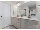 Bright bathroom featuring a double vanity with white countertops, grey cabinets and a large mirror at 1645 Unison Dr, Charlotte, NC 28262