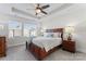 Inviting bedroom with a ceiling fan, tray ceiling, a wooden bed frame, and bright windows at 1645 Unison Dr, Charlotte, NC 28262