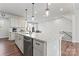Bright kitchen features a large island with a sink, pendant lighting, and backyard view at 1645 Unison Dr, Charlotte, NC 28262