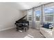 Bright living room featuring a black grand piano, a comfortable loveseat, and natural light from the windows at 1645 Unison Dr, Charlotte, NC 28262