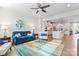 Open-concept living room featuring a colorful rug, ceiling fan, and seamless transition to the kitchen at 1645 Unison Dr, Charlotte, NC 28262