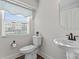 Bright powder room features a pedestal sink, toilet, and window with natural light at 1645 Unison Dr, Charlotte, NC 28262