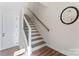 Bright staircase features wood stairs, modern black metal railing, and a round mirror on the wall at 1645 Unison Dr, Charlotte, NC 28262