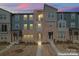 Charming townhome exterior with a blend of modern and traditional architectural elements under a dusk sky at 1645 Unison Dr, Charlotte, NC 28262