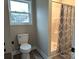 This bathroom is equipped with tile floors, a toilet, and a shower with a curtain at 203 S Hill Ave # 3, Albemarle, NC 28001