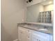 This spacious bathroom includes granite counters, double sinks, and a shower with a curtain at 203 S Hill Ave # 3, Albemarle, NC 28001