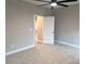Bright bedroom featuring a ceiling fan, carpet flooring, and a large closet at 203 S Hill Ave # 3, Albemarle, NC 28001