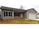 Inviting home features gray vinyl siding, a covered front porch, and a convenient attached one-car garage at 203 S Hill Ave # 3, Albemarle, NC 28001