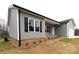 Charming one-story home with gray siding, black shutters, brick foundation, and well-manicured front lawn at 203 S Hill Ave # 3, Albemarle, NC 28001