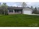 Attractive single-story home featuring gray siding, black shutters, a pristine lawn, and an attached two-car garage at 203 S Hill Ave # 3, Albemarle, NC 28001