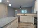 Bright, open kitchen features granite countertops, an island, modern stainless steel appliances, and white cabinets at 203 S Hill Ave # 3, Albemarle, NC 28001
