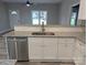 Modern kitchen features stainless steel appliances, granite countertops, double sinks, and a breakfast bar overlooking the living area at 203 S Hill Ave # 3, Albemarle, NC 28001