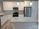 Bright kitchen features an island, granite countertops, stainless steel appliances and white cabinets at 203 S Hill Ave # 3, Albemarle, NC 28001
