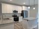 Modern kitchen featuring white cabinets, granite countertops, stainless steel appliances, and an island with seating at 203 S Hill Ave # 3, Albemarle, NC 28001