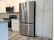 Stainless steel refrigerator and appliances featured in this modern white kitchen with granite countertops at 203 S Hill Ave # 3, Albemarle, NC 28001