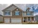Two story home with a two car garage, brick facade, covered front porch and decorative shutters at 214 Giant Oak Ave, Statesville, NC 28677