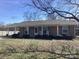Charming single-story brick home with covered front porch, rocking chairs and manicured shrubs at 2883 Westfield Nw Ave, Concord, NC 28027