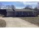 View of the property showcasing a long concrete driveway leading to the brick home with a covered front porch at 2883 Westfield Nw Ave, Concord, NC 28027