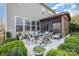 A cozy backyard with a patio, outdoor dining set, and a screened-in porch, surrounded by lush greenery at 3004 Fallondale Rd, Waxhaw, NC 28173