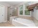 Bright bathroom featuring a soaking tub, glass enclosed shower, and large window at 3004 Fallondale Rd, Waxhaw, NC 28173