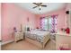 Cute bedroom with pink walls, a bed, a nightstand, and a window at 3004 Fallondale Rd, Waxhaw, NC 28173