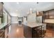 Open-concept kitchen with island, stainless steel appliances, dark wood cabinets, and hardwood floors at 3004 Fallondale Rd, Waxhaw, NC 28173