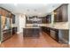 Modern kitchen featuring dark wood cabinets, granite countertops, stainless steel appliances, and hardwood floors at 3004 Fallondale Rd, Waxhaw, NC 28173