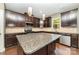 Modern kitchen with dark wood cabinets, granite countertops, stainless steel appliances, and a center island at 3004 Fallondale Rd, Waxhaw, NC 28173