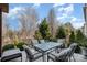 Outdoor dining area with a glass table and seating for six, surrounded by landscaping and a black metal fence at 3004 Fallondale Rd, Waxhaw, NC 28173