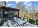 View of a backyard patio with a large glass dining table, comfortable seating, and a screened-in porch area at 3004 Fallondale Rd, Waxhaw, NC 28173