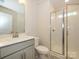 Clean bathroom with a glass-enclosed shower and modern vanity with gray cabinetry at 3904 Craig Ave, Charlotte, NC 28211
