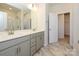 Bright bathroom featuring a double vanity, marble floors and glass shower door at 3904 Craig Ave, Charlotte, NC 28211