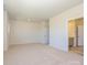 Open bedroom leading to bathroom showcases neutral carpet and recessed lighting at 3904 Craig Ave, Charlotte, NC 28211
