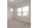 Sunlit bedroom featuring neutral carpet and a large window overlooking the neighborhood at 3904 Craig Ave, Charlotte, NC 28211